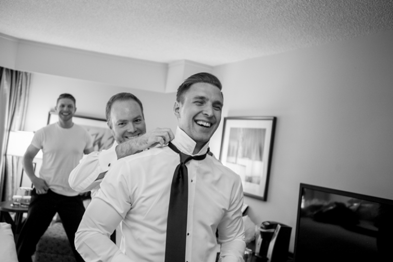Groomsmen doing up their ties before the wedding