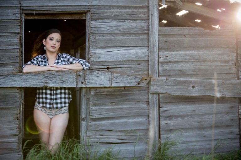 Girl leaning on board in doorway boudoir session 