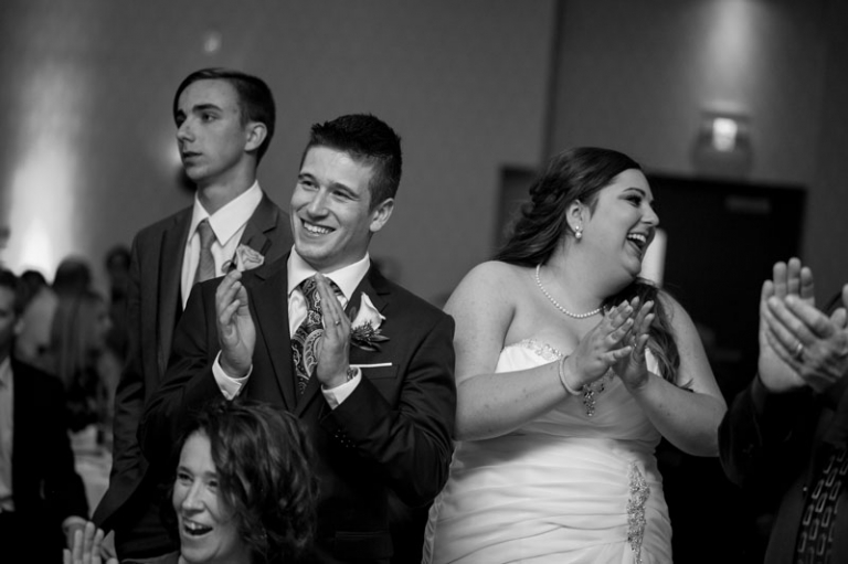 Bride and Groom in crowd laughing at reception