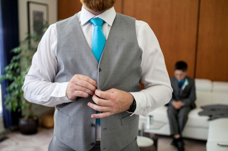 Groom doing up buttons