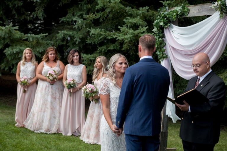 bride and groom holding hands during ceremony