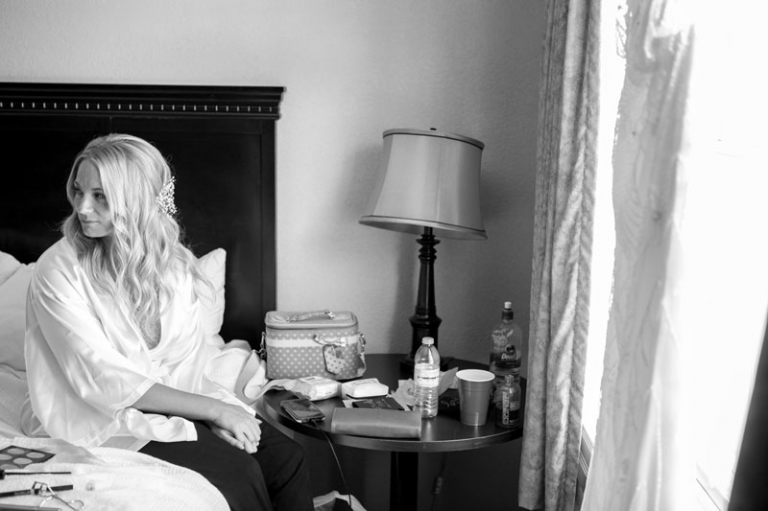 Bride sitting on bed with dress in wedding 