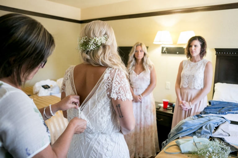 Bride's mom doing up her dress