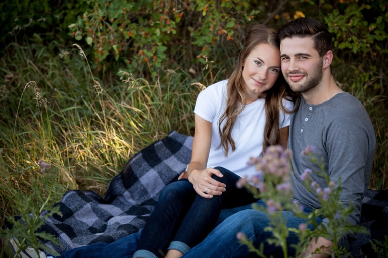 couple looking up at camera from plaid blanket