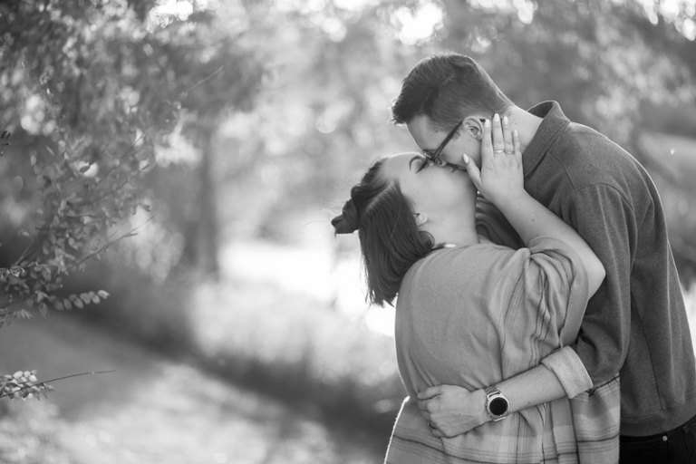 Engaged couple kissing during engagement session with Collin Stumpf