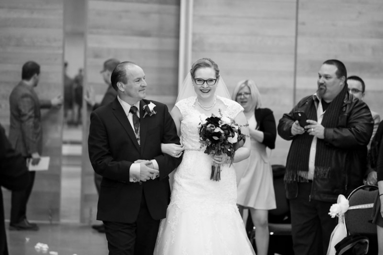 Bride walking down aisle with father at RCMP Heritage Centre Wedding in Regina