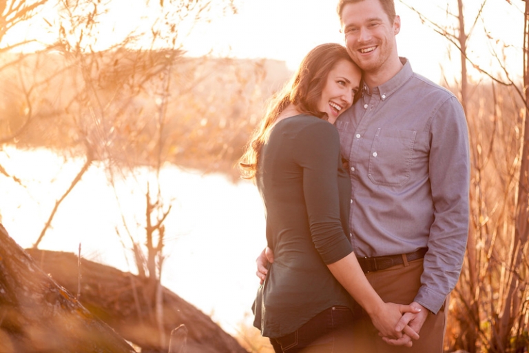 Couple cuddling by river in Regina, Saskatchewan