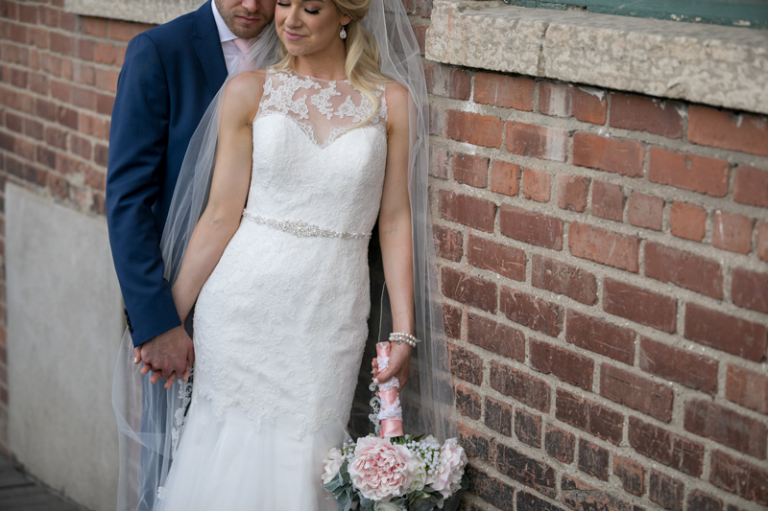 Bride and Groom against brick wall