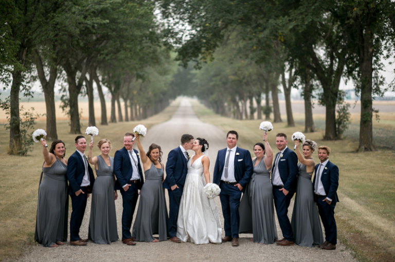 bridal party on tree lined gravel road